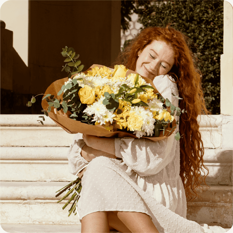 Joyful woman embracing a vibrant bouquet of yellow roses and chrysanthemums, representing flowers that speak emotions, perfect for special deliveries